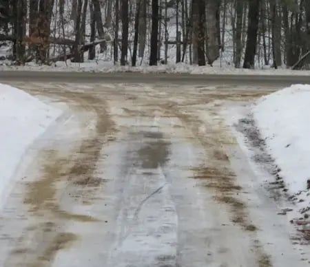 Driveway treated with sand as a lawn-friendly alternative to rock salt.